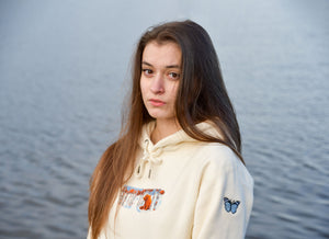 A model wears the bear hoodie in front of a blue water backdrop.