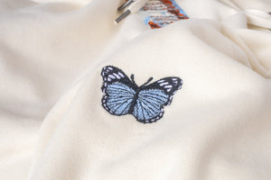 A close up of the embroidered blue and black butterfly on the left shoulder.