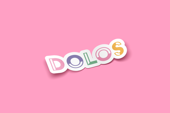 View from an angle - A white outlined sticker that has Dolos written in a colorful font.